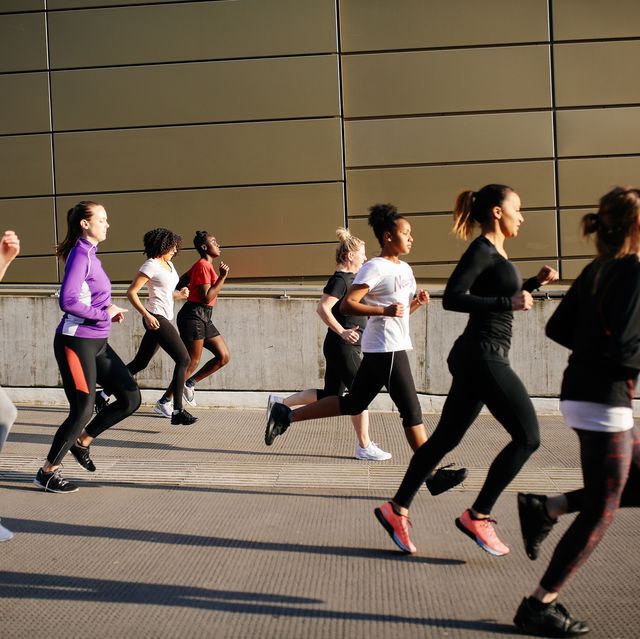 group of young women running in city setting