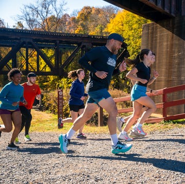 group of runners on uphill gravel path under bridge group of runners on uphill gravel path under bridge