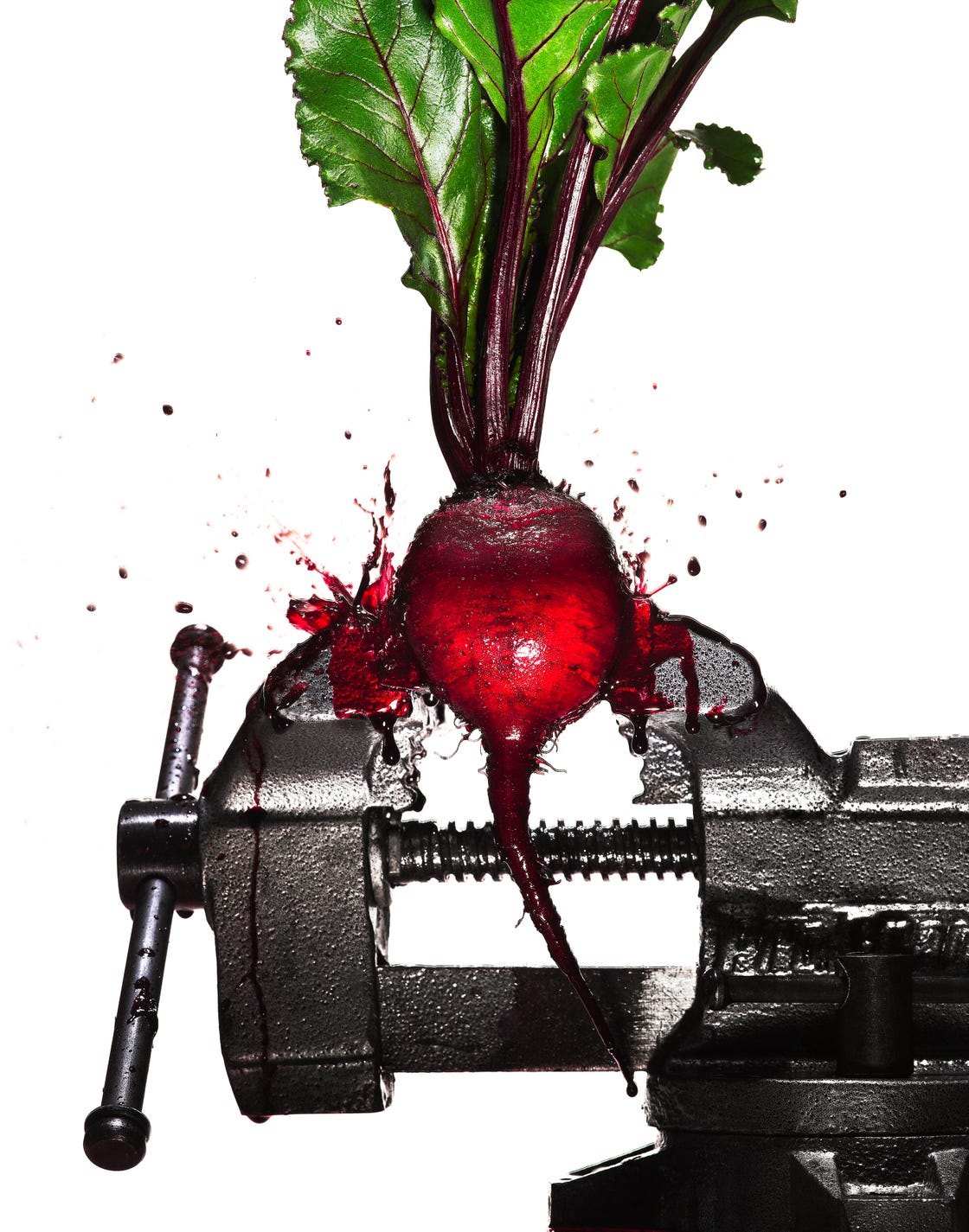 a beet in a vise getting squashed and exploding beet juice