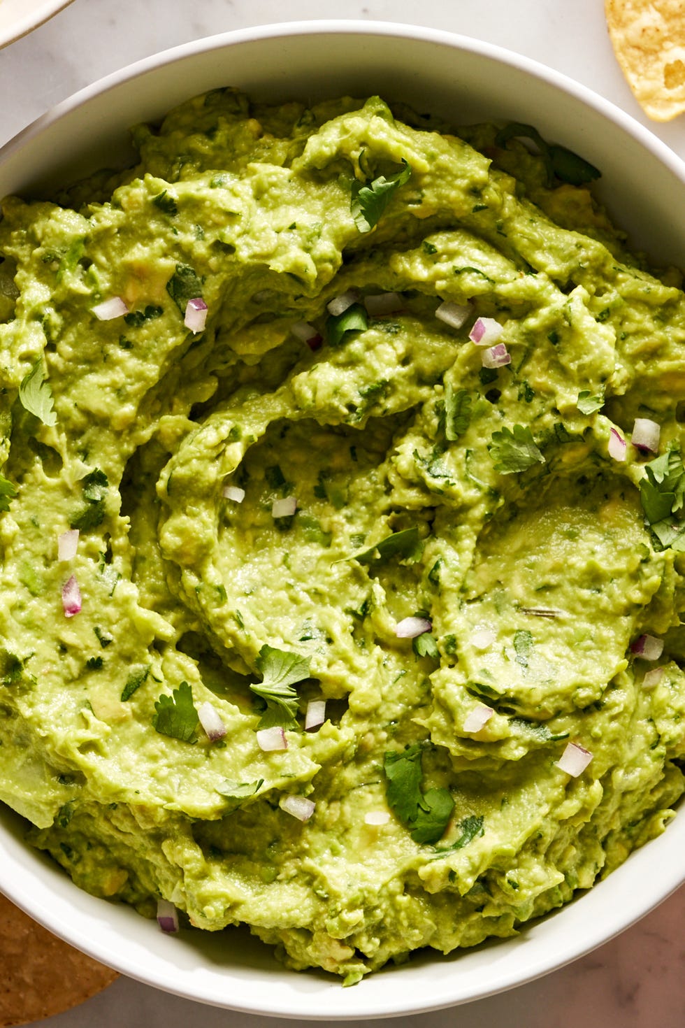 guacamole with diced red onion, cilantro, and with chips