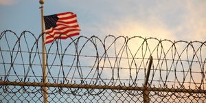 16 october 2018, cuba, guantanamo bay a us american flag blows behind a barbed wire fence in the wind the infamous camp has now existed for almost 17 years 40 inmates are still being held there to dpa "the aging prisoners of guantánamo bay" of 27112018 photo maren hennemuthdpa photo by maren hennemuthpicture alliance via getty images