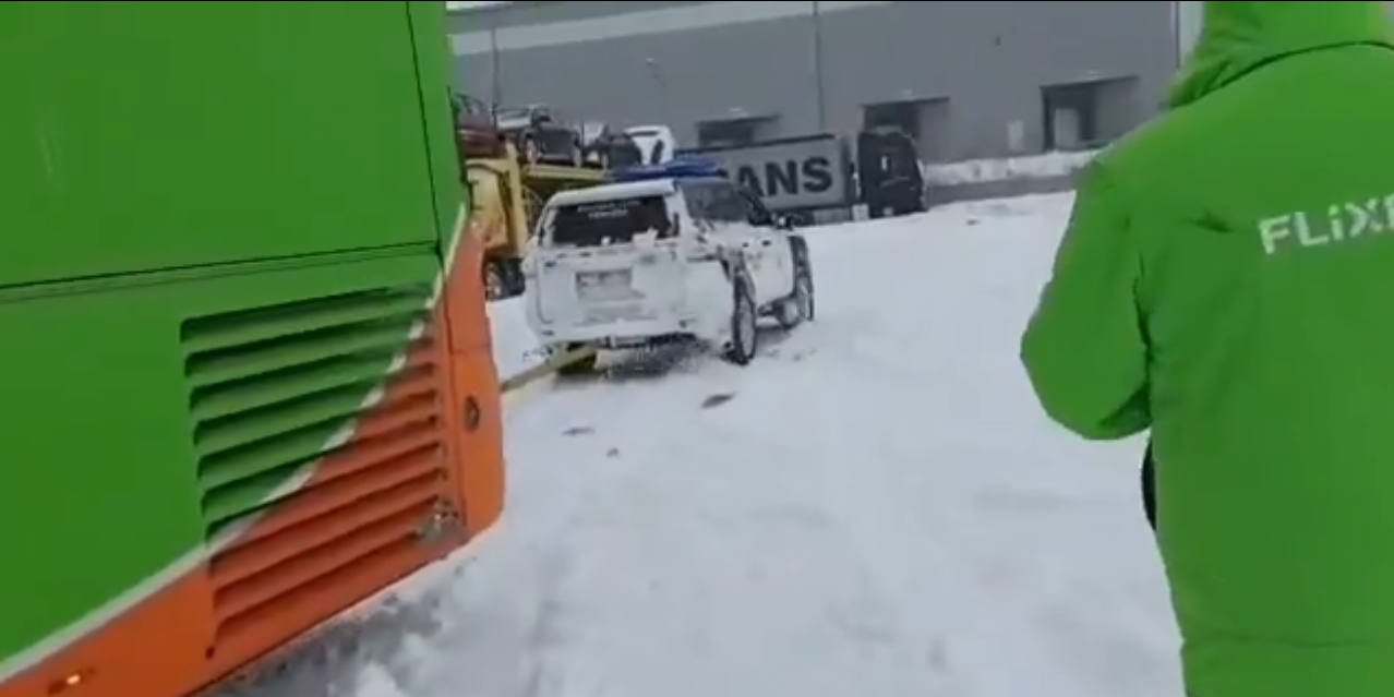un toyota land cruiser libera a un autobús de la nieve