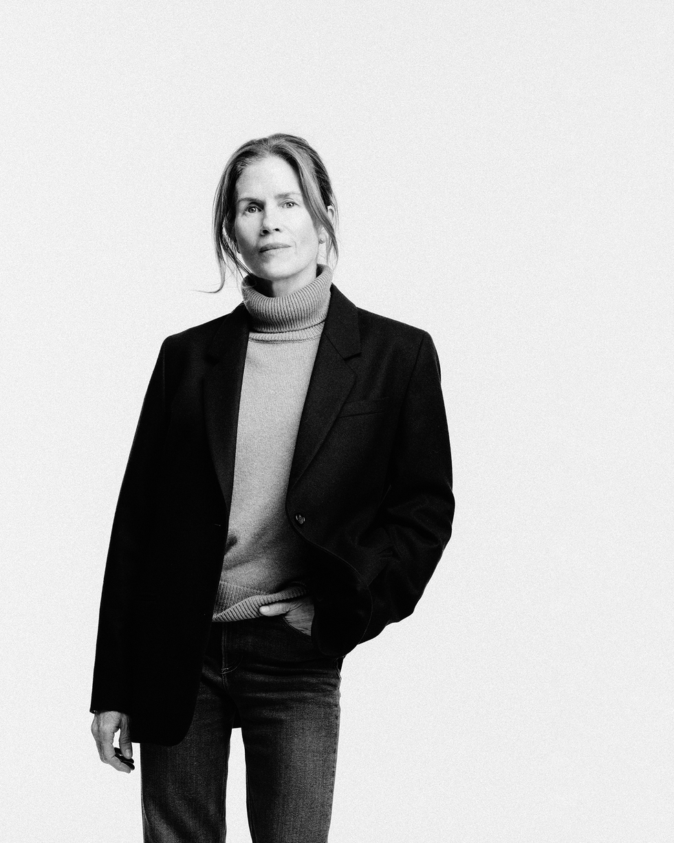 a person wearing a black blazer and a turtleneck sweater