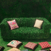 a topiary sofa with multicolored cushions on and surrounding
