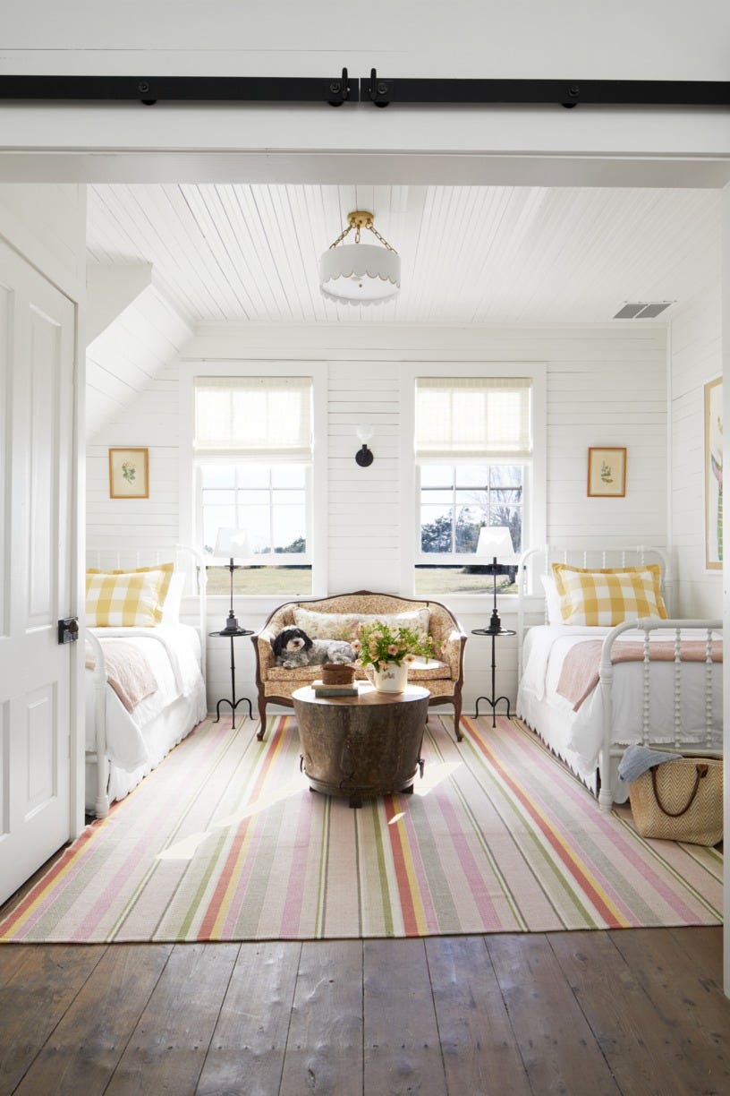 white farmhouse bedroom with two twin jenny lind beds and antique settee between them