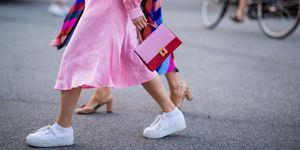 vrouw met roze jurk en witte sneakers