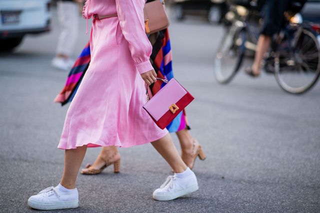 vrouw met roze jurk en witte sneakers