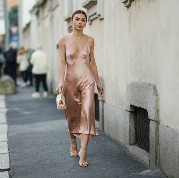 vrouw op straat loopt in zijde jurk