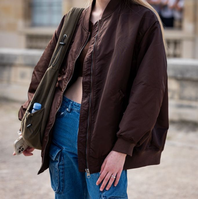 Come indossare la giacca bomber: idee look moda Autunno 2023  --- (Fonte immagine: https://hips.hearstapps.com/hmg-prod/images/guest-wears-a-brown-bomber-jacket-and-blue-cargo-jeans-news-photo-1699622116.jpg?crop=1.00xw:0.668xh;0,0.254xh&resize=2000:*)