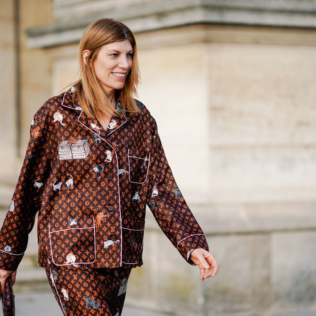 A guest wears a Vuitton brown monogram pyjama outfit, outside