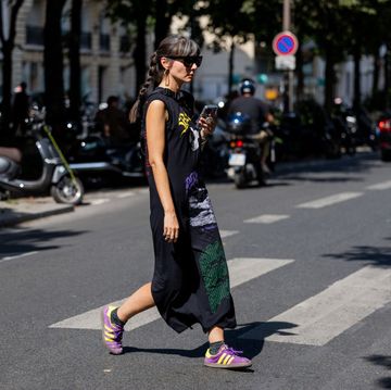 a woman walks across the street at paris menswear week wearing a pair of adidas sambas to illustrate a story about the best amazon prime day sneaker deals of 2023