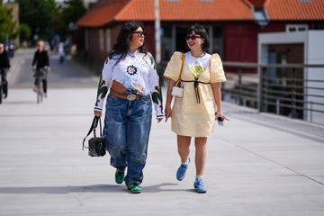 twee vrouwen lopen over straat tijdens kopenhagen fashion week