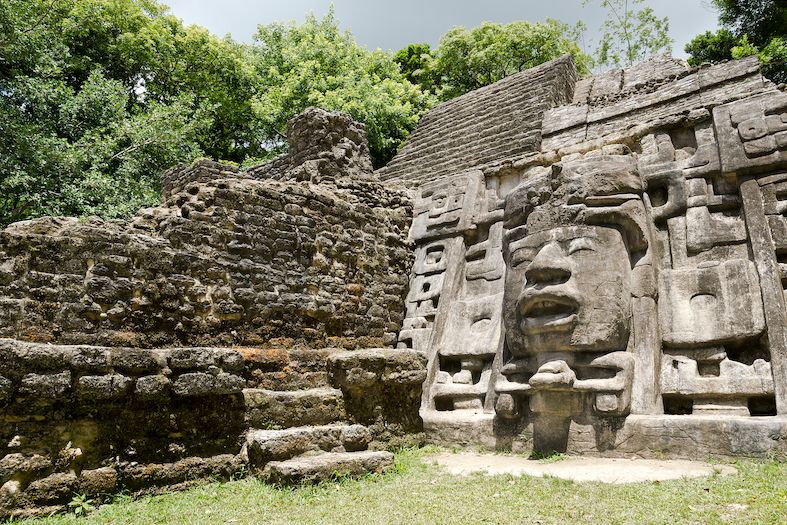 an ancient stone temple in belize with a face carved into the rock