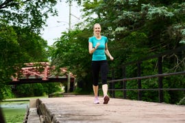 person walking on a wooden pathway near a canal