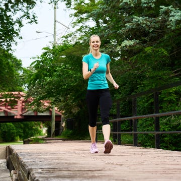 person walking on a wooden pathway near a canal person walking on a wooden pathway near a canal