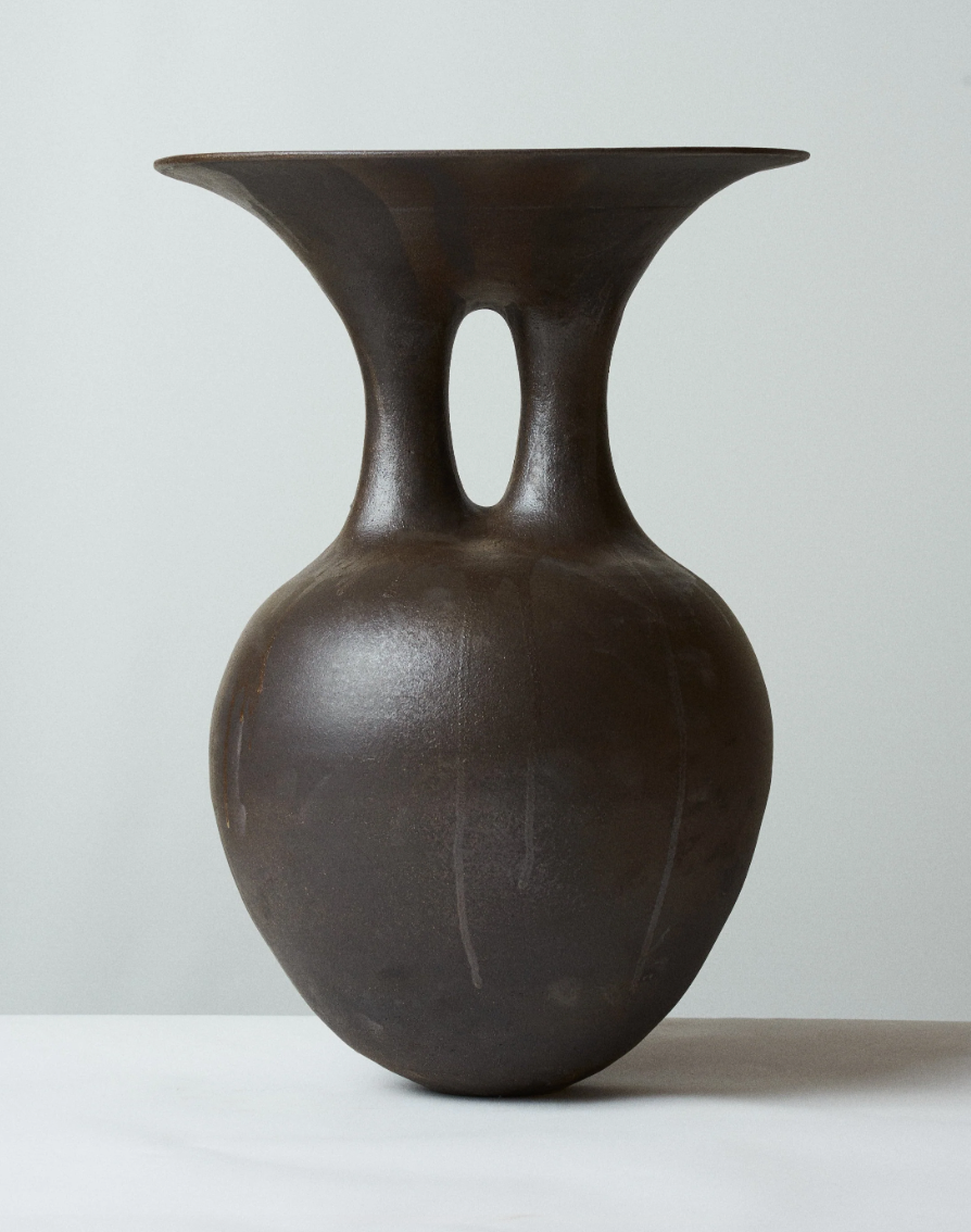 a black vase on a white surface