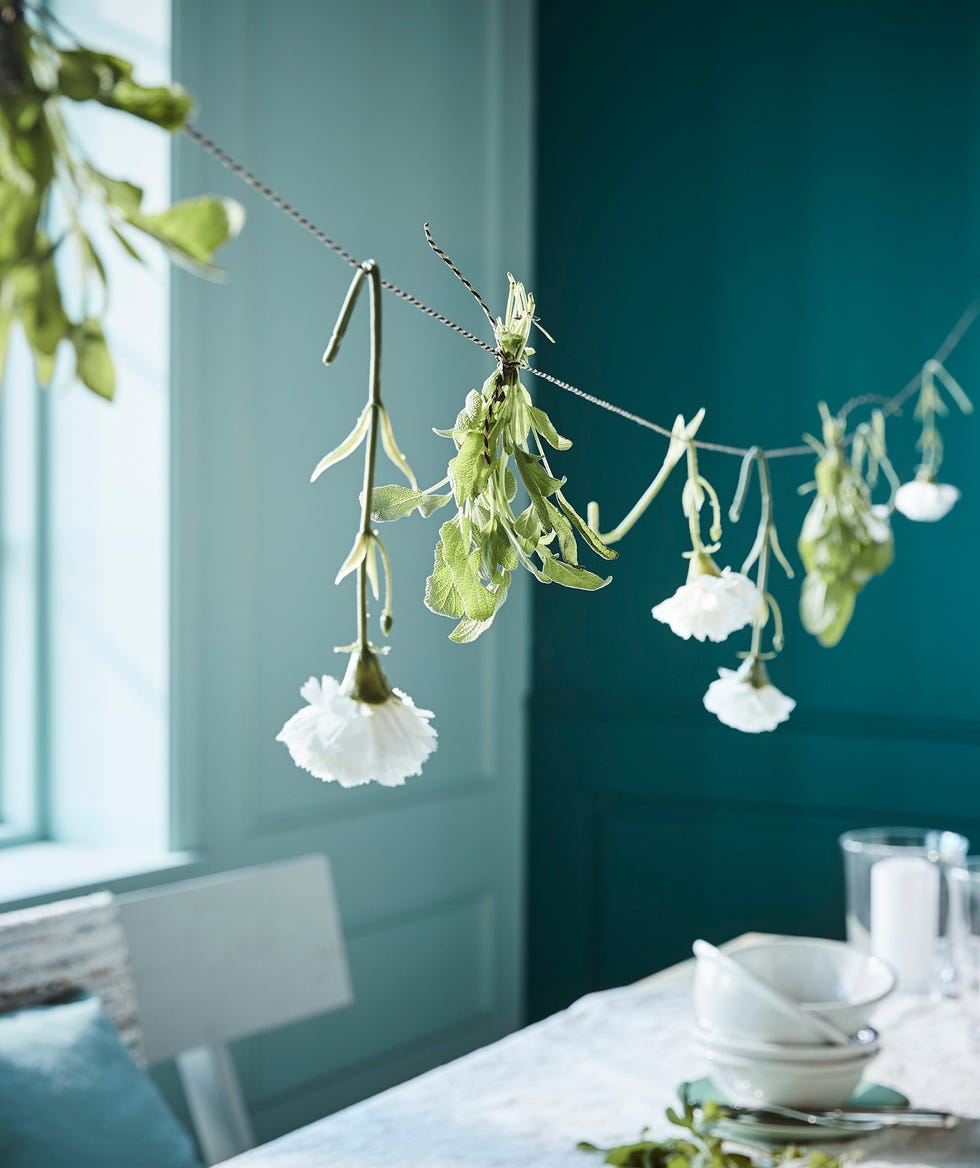 mesa decorada con una guirnalda de flores blancas