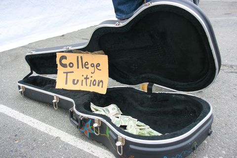 guitar case open with money for tips with "college tuition" sign