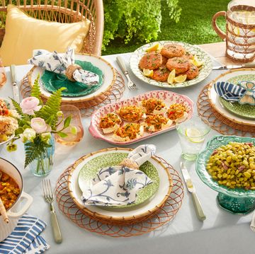 a table outdoors set with salmon cakes, deviled crab, stewed okra, turkey wings and beans