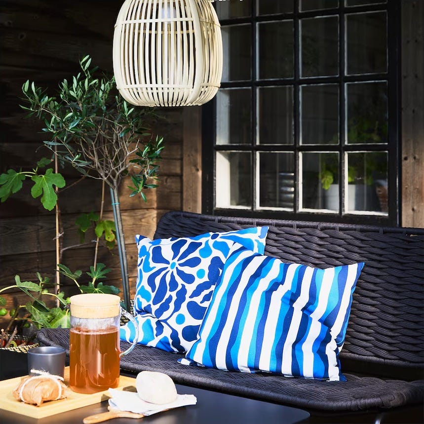 cozy outdoor seating area with patterned cushions and a drink