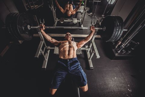 Guy bench press training in gym