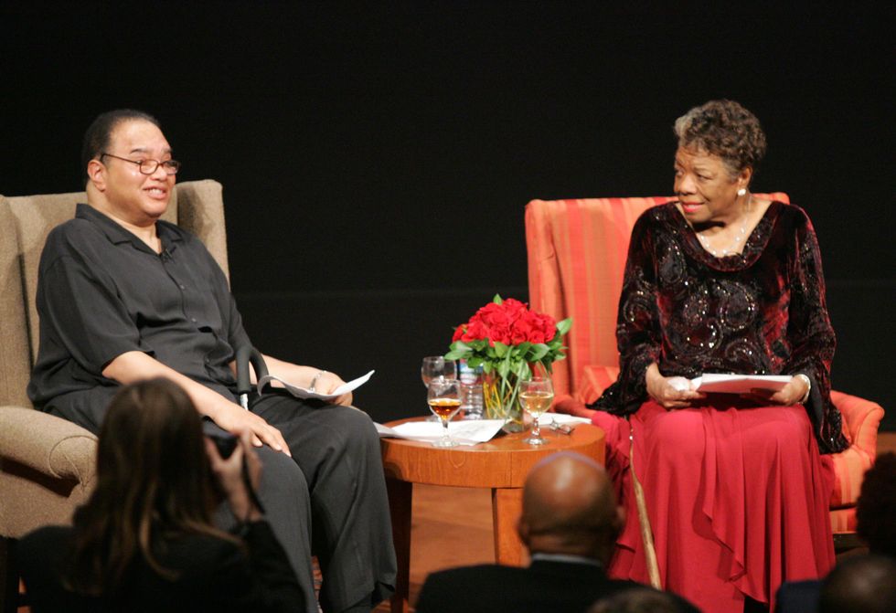 guy johnson and maya angelou sitting in chairs on a stage during an honorary event
