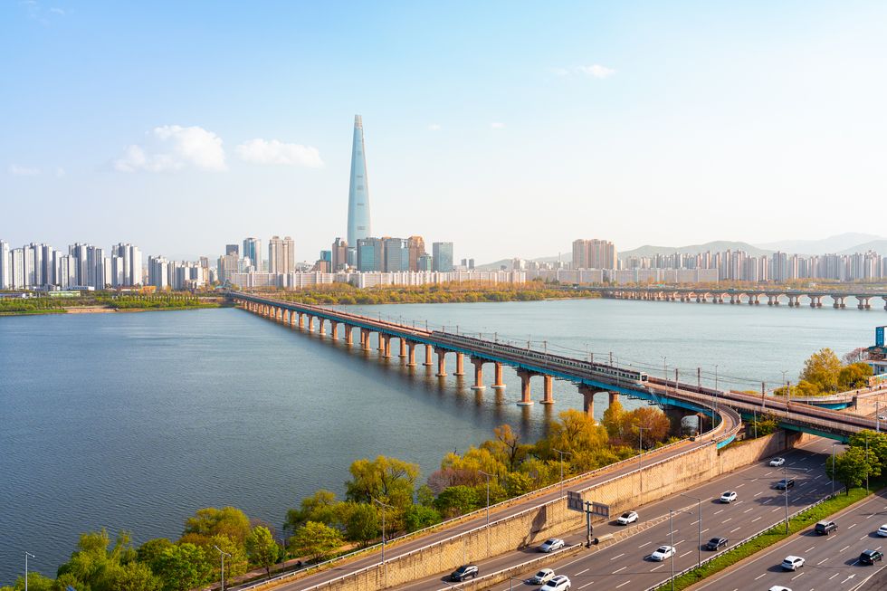 gyeonggi province bridge over river with buildings against sky, south korea