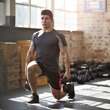 gym instructer doing lunges with kettlebells
