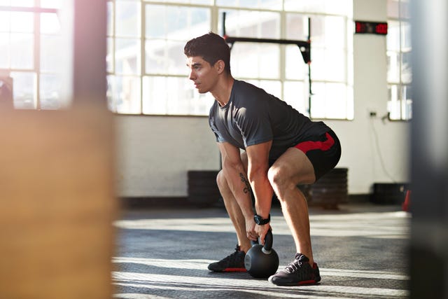 gym instructor lifting kettlebell at urban gy