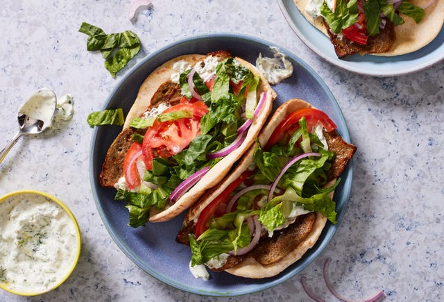 gyro sandwich with lamb, tzatziki, lettuce, tomato and onion in a pita