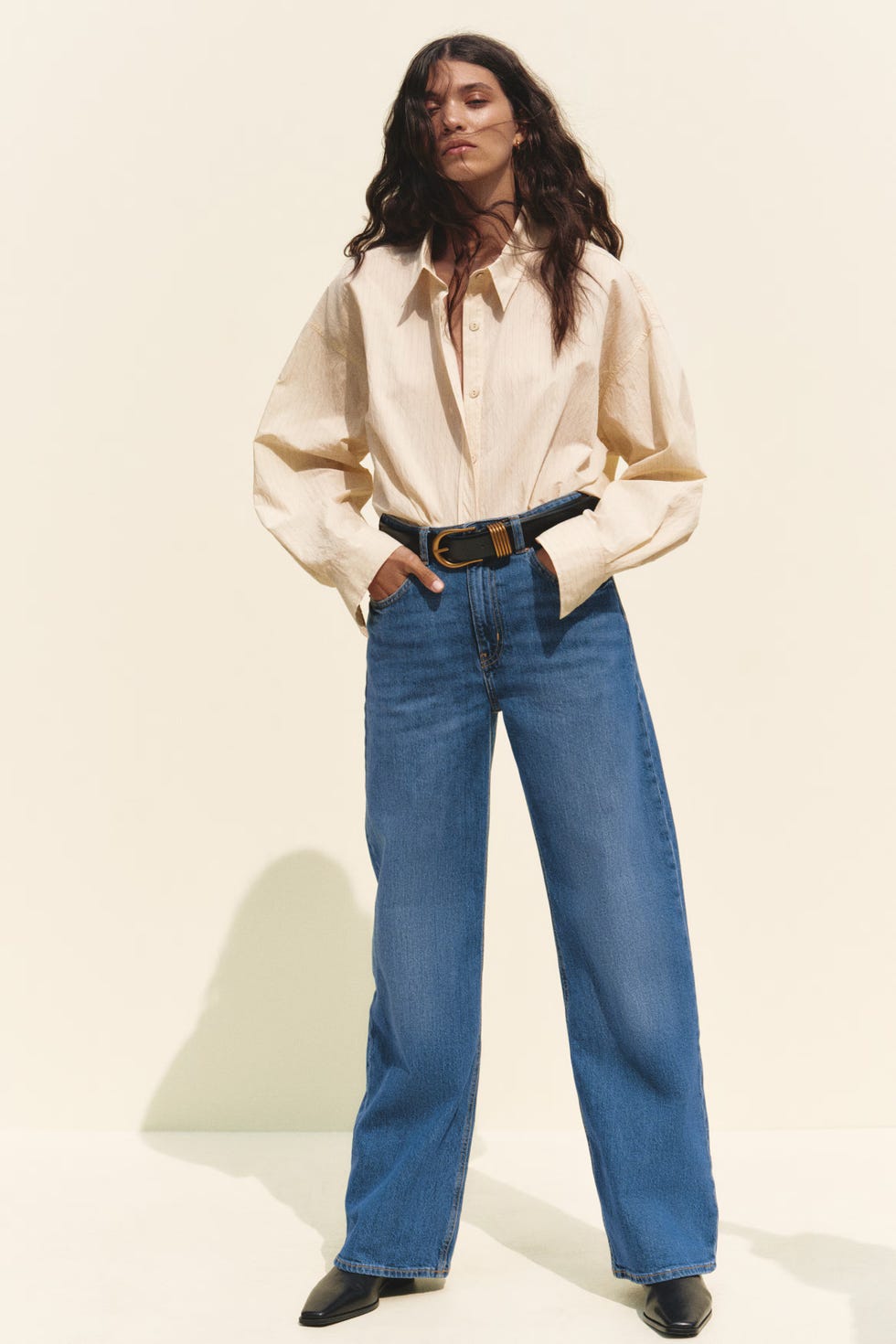 model showcasing a stylish outfit with a buttoned shirt and wideleg jeans
