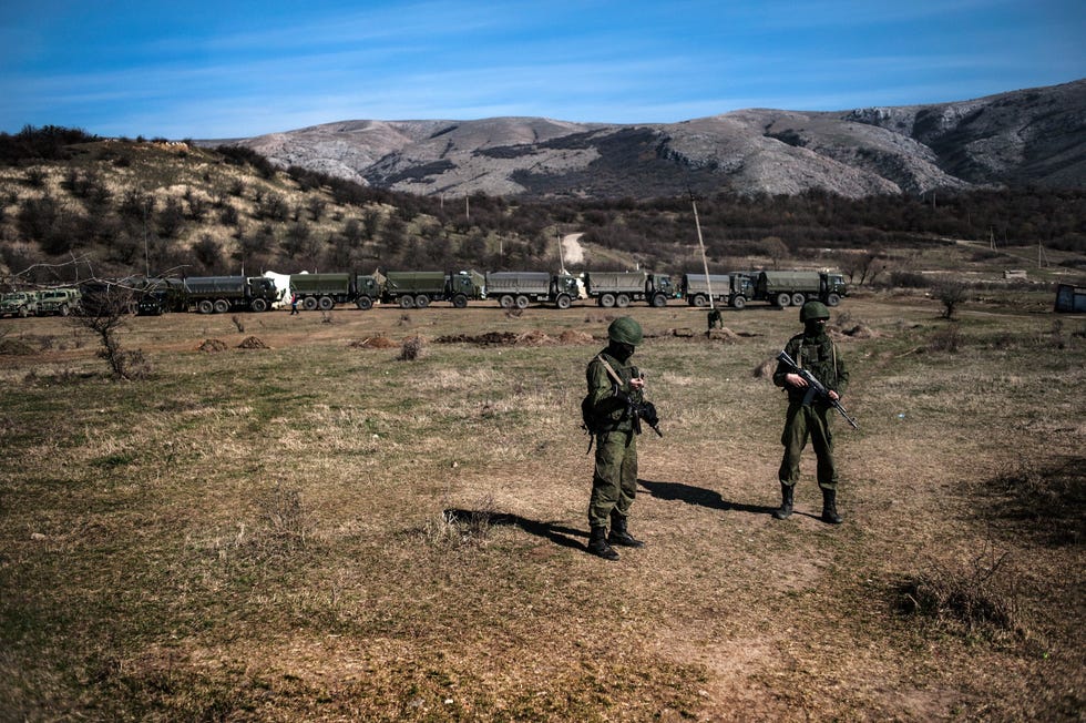Nietgedentificeerde militairen vermoedelijk Russische militairen worden gezien voor een konvooi van militaire vrachtwagens in de buurt van een Oekraense marinebasis Alle Oekraense militaire bases op het Krimschiereiland werden weken voor de invasie van Oekrane geblokkeerd door de ongedentificeerde militaire soldaten