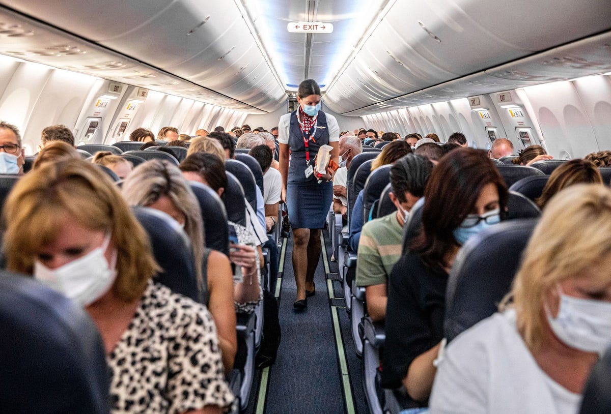 Passagiers met mondkapjes op zitten in een van de eerste vliegtuigen die sinds begin 2020 toen vrijwel alle vluchten als gevolg van de COVID19uitbraak werden geannuleerd weer tussen Amsterdam en het Bulgaarse Boergas vliegen Hoewel de meeste commercile passagiersvliegtuigen zijn uitgerust met zeer efficinte HEPAluchtfilters helpen mondkapjes te voorkomen dat passagiers worden besmet of hun medereizigers aansteken