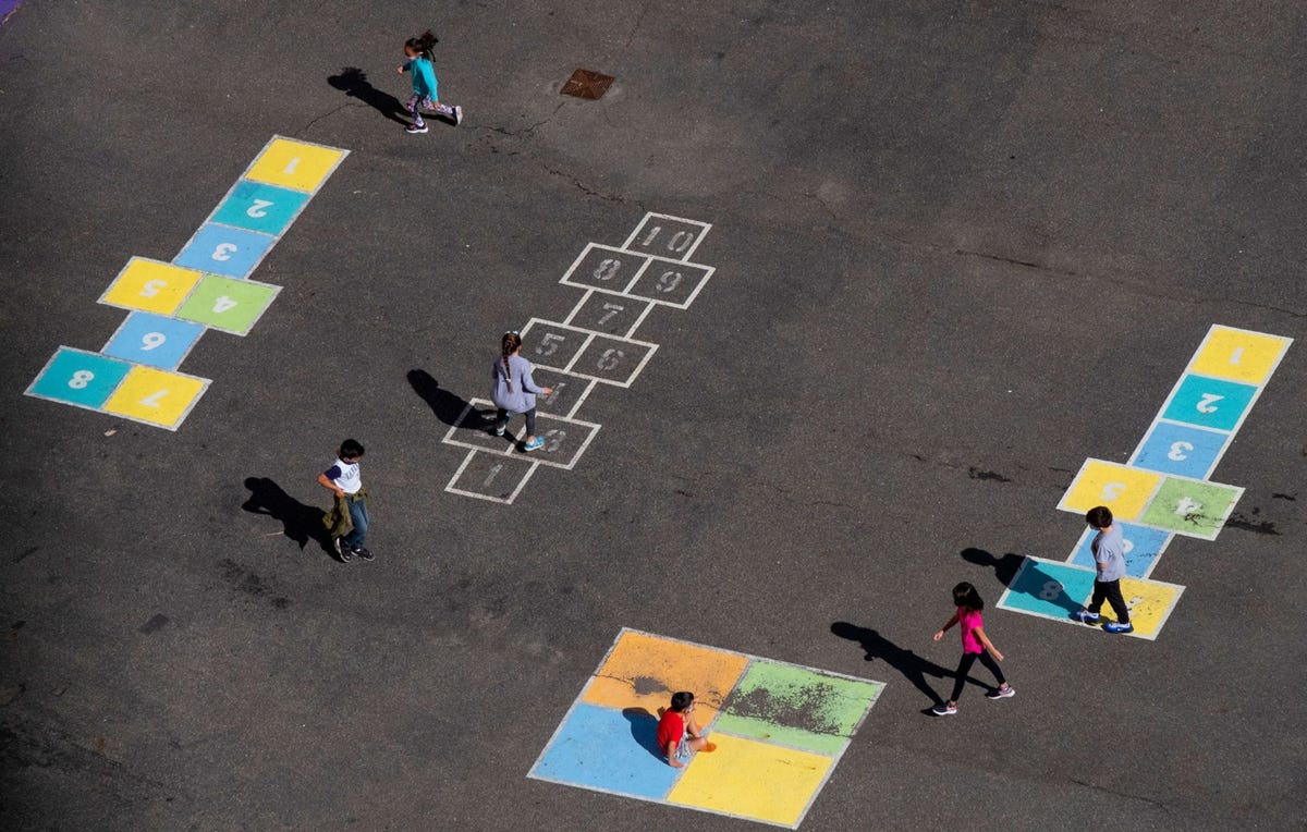 Een groepje kinderen speelt buiten en neemt de afstandsregels in acht op een schoolplein bij aan basisschool in Manhattan op 1 oktober 2020