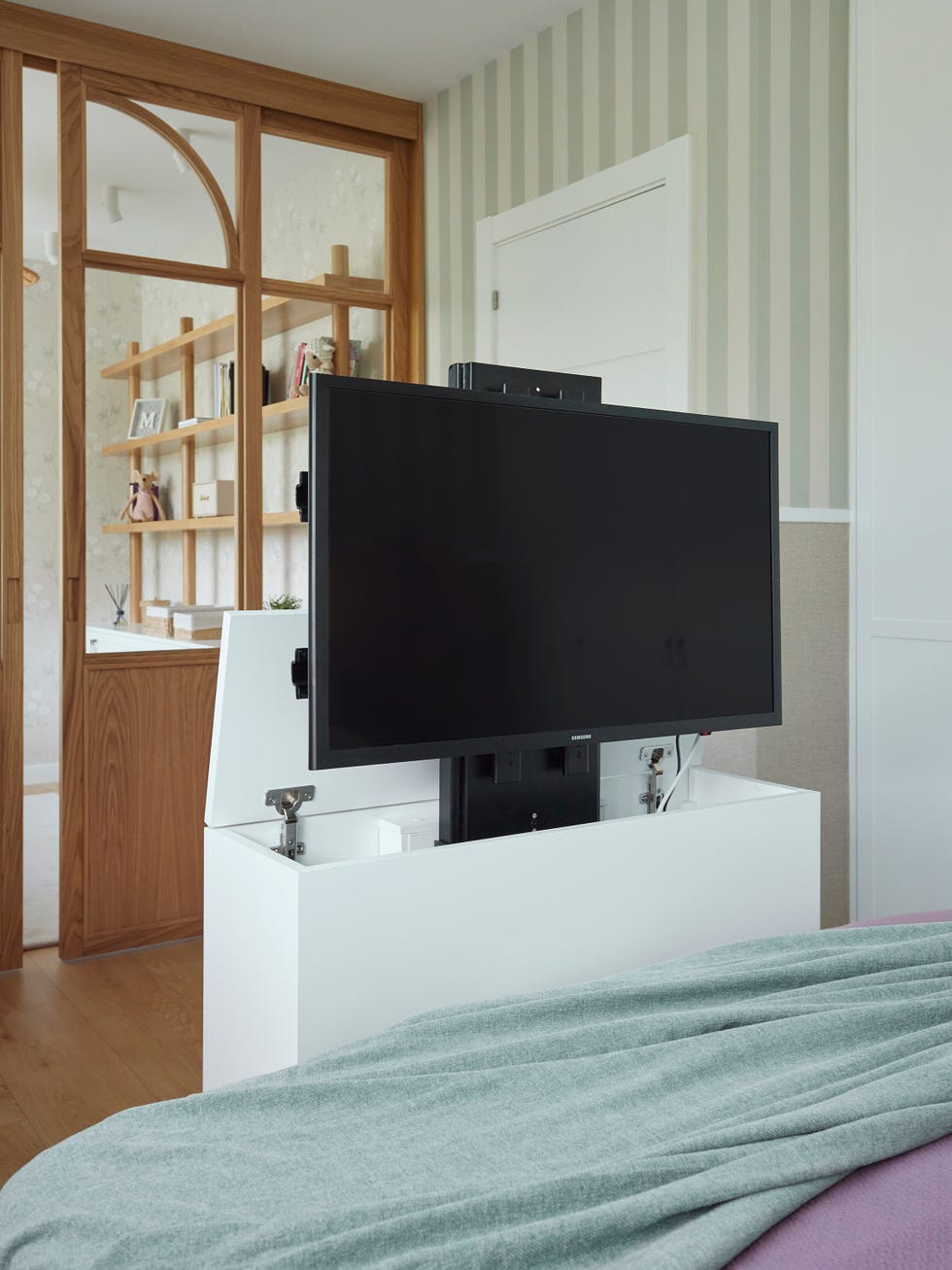 mueble blanco con televisión a los pies de la cama