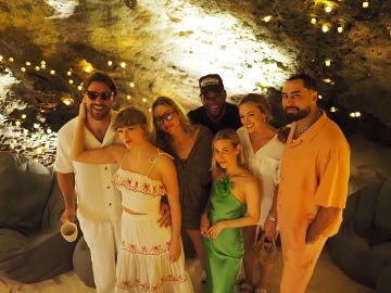 group of people posing together in a cave setting with soft lighting