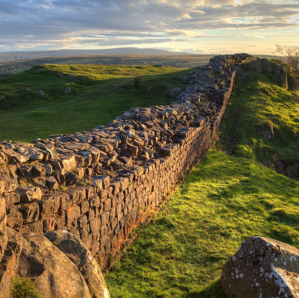 a stretch of hadrian's wall at walton's crags in northumberland, england, coloured by the setting sun