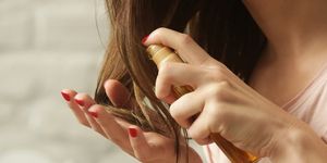 hair care　woman applying oil on hair ends　 split hair tips, dry hair or sun protection concept