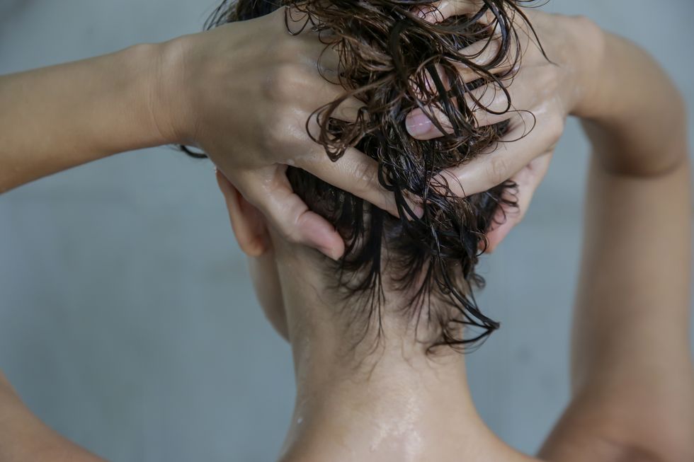 hair shampooing and scalp massage back view of woman in the shower cabin