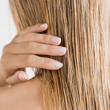 Woman touching damp blonde hair thinning hair