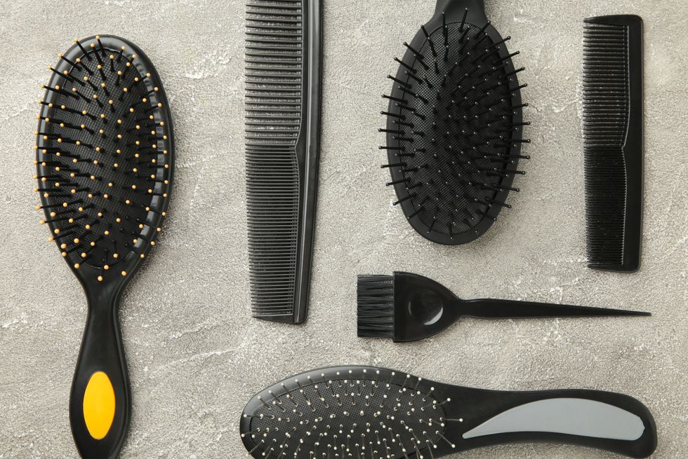 hair tools, beauty and hairdressing concept different brushes or combs on grey background