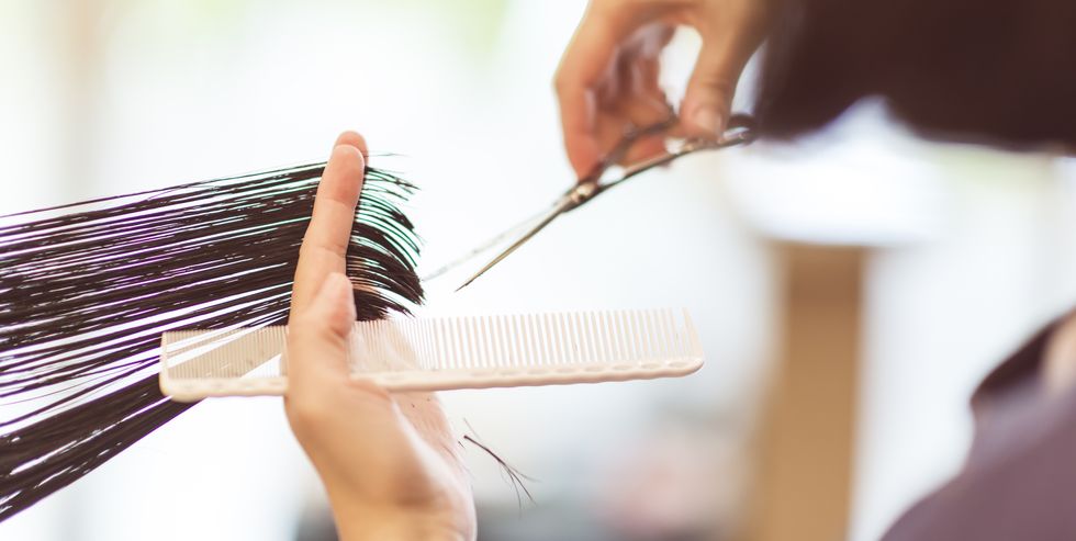 hairdresser using scissors to cut hair