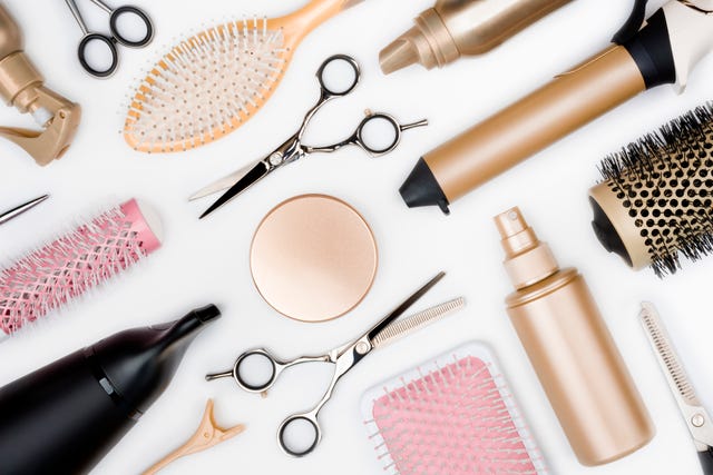 Hairdressing tools and various hairbrushes on white background top view