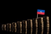 haitian flag with lot of coins isolated on black background