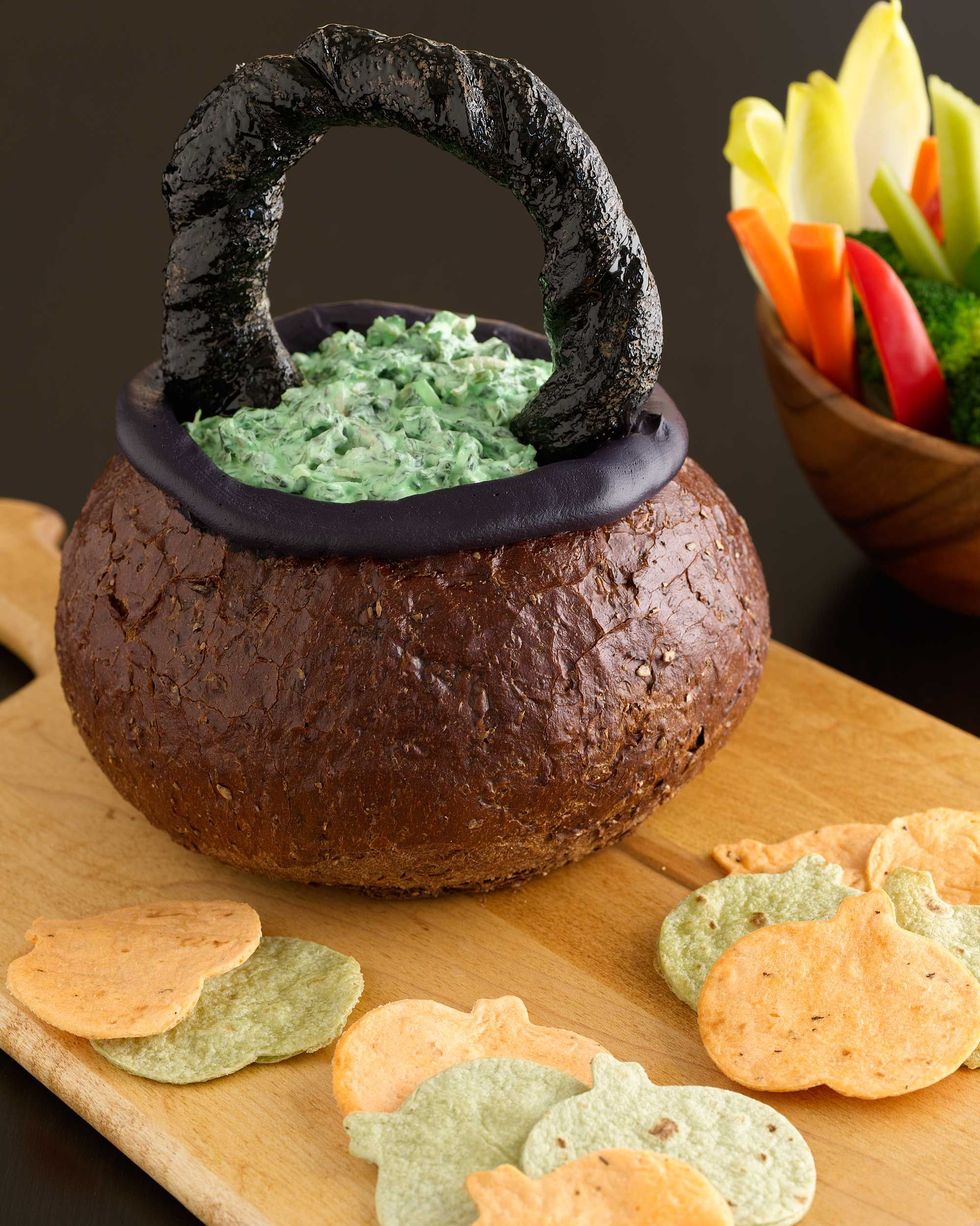 spinach dip in bread bowl with a bread handle to look like a cauldron and pumpkin shaped tortilla chips