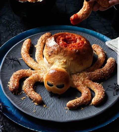 breadstick dough shaped into a spider with an abdomen bowl of marinara sauce