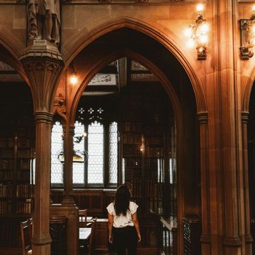woman walking in spooky gothic library