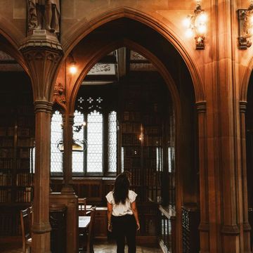 woman walking in spooky gothic library