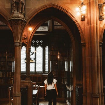 woman walking in spooky gothic library woman walking in spooky gothic library