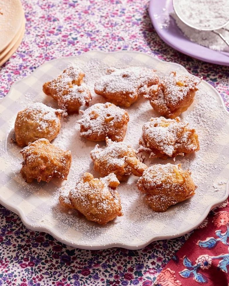 apple fritters on purple plate with powdered sugar